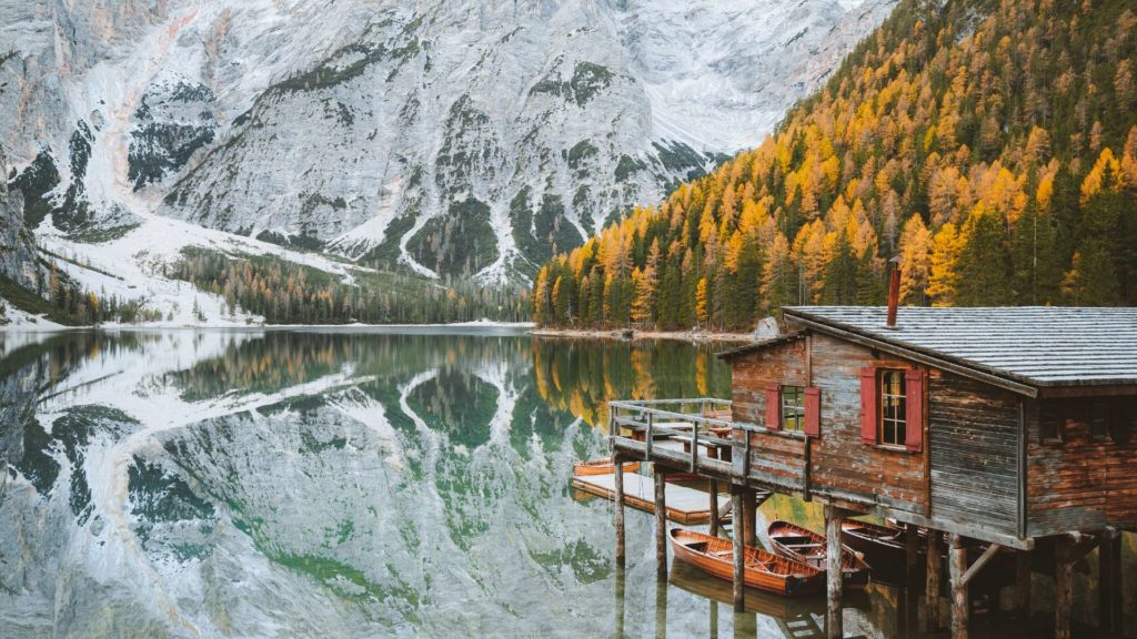 Winter wonderland at Lago di Braies in the Dolomites, South Tyrol, Italy, with snow-covered shores and majestic mountain peaks.