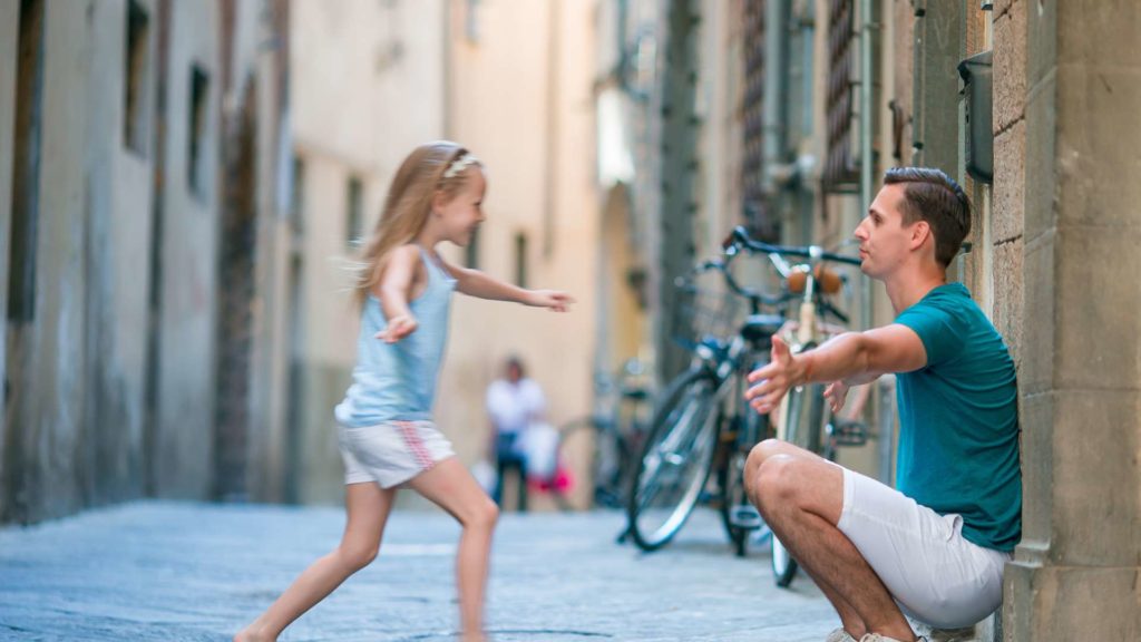 A joyful father and his adorable daughter exploring the beauty of Rome during a sunny summer Italian vacation.
