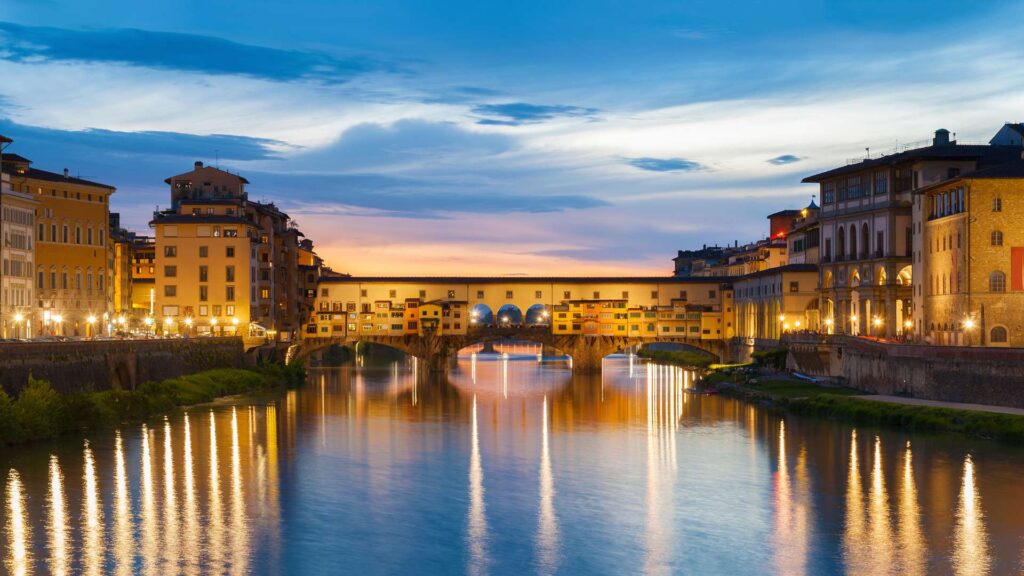 Italy Central Wonders - Breathtaking view of Ponte Vecchio in Florence, Italy, the iconic medieval bridge spanning the Arno River, adorned with historic shops and architecture.