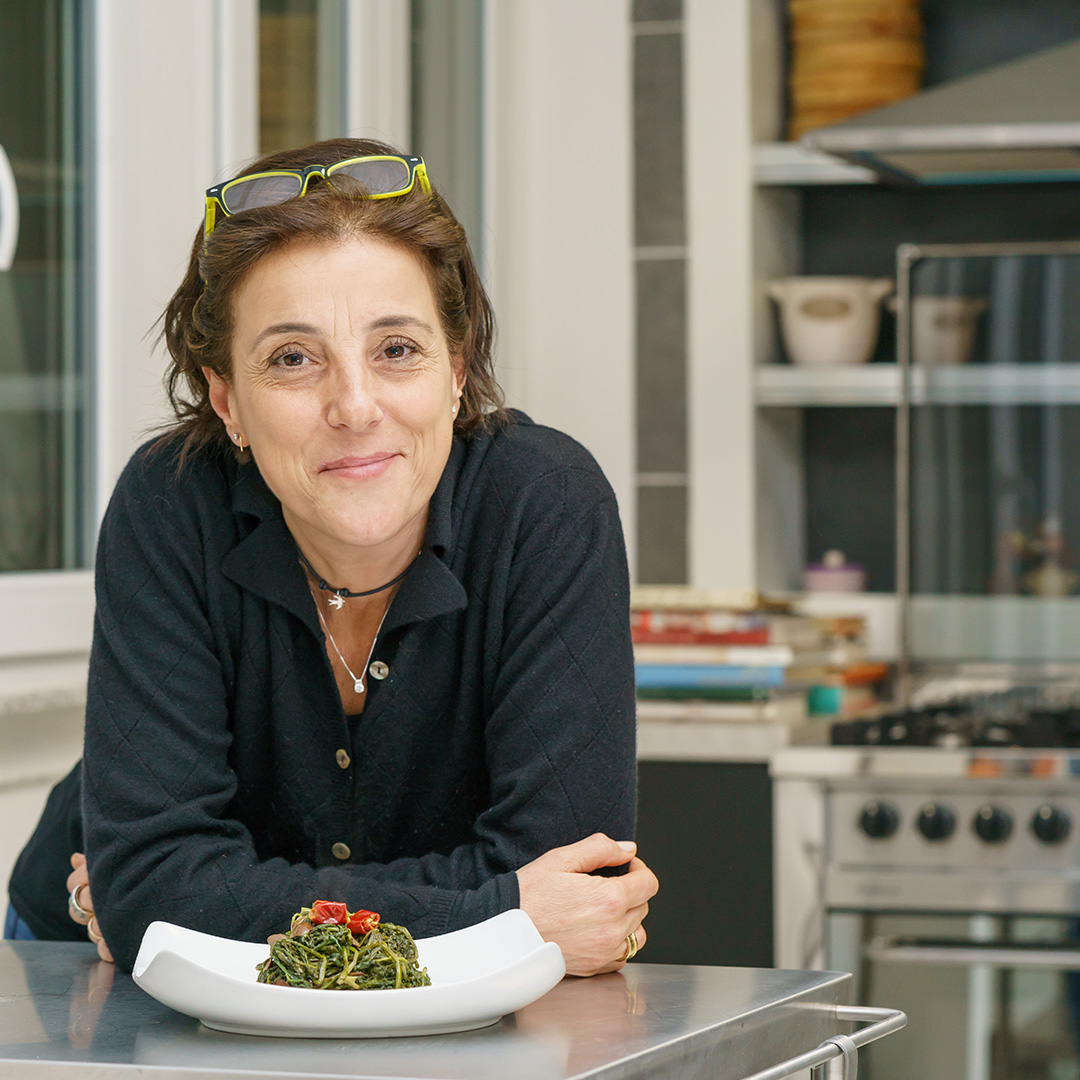 A woman sitting at a table with a plate of food.