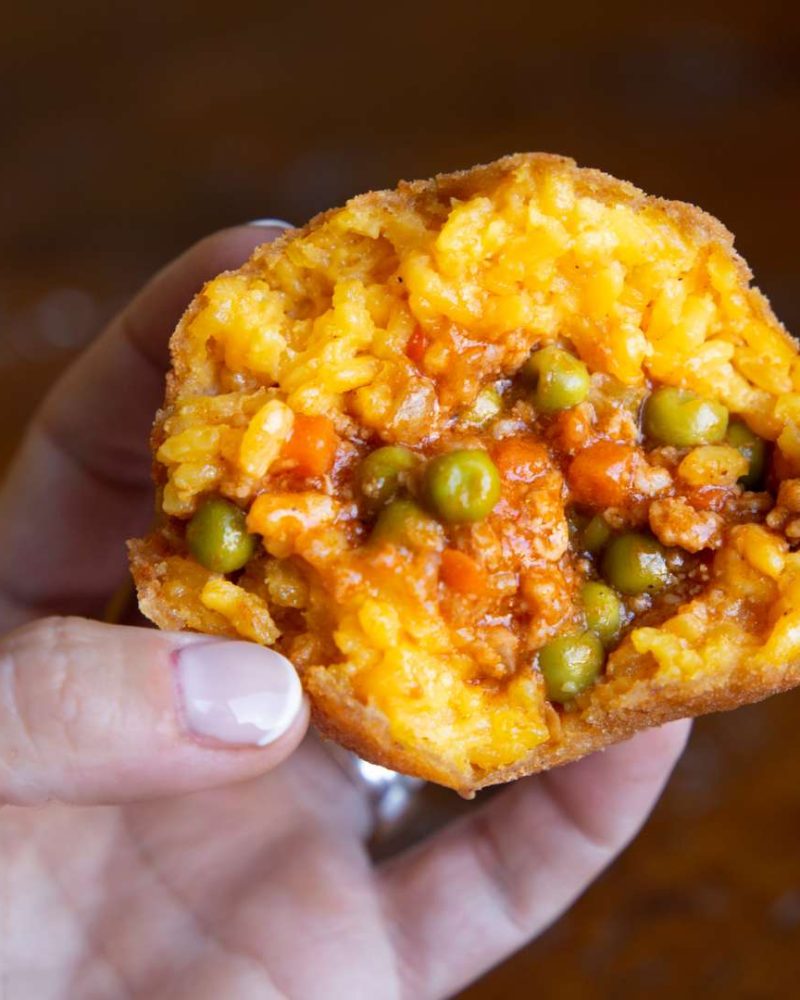 Close-up of Arancino, a typical food of Palermo, Sicily, showcasing golden-fried rice ball filled with savory goodness.