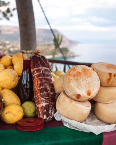 Spread of Calabrian delights – cheese, wine, and Capocollo, showcasing the region's gastronomic excellence and culinary traditions.