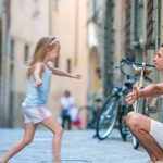 A joyful father and his adorable daughter exploring the beauty of Rome during a sunny summer Italian vacation.
