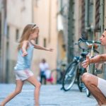 A joyful father and his adorable daughter exploring the beauty of Rome during a sunny summer Italian vacation.