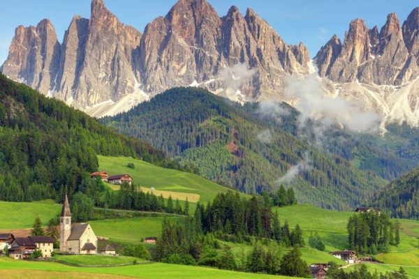 Panoramic view of the Dolomites in Val di Funes, Italy, showcasing the majestic mountain peaks and idyllic alpine landscapes.