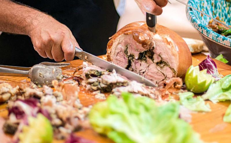 Close-up of succulent Porchetta from Umbria, Italy, featuring crispy golden skin and flavorful, tender layers of seasoned pork.