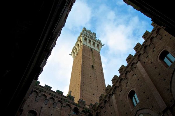 Majestic view of Torre del Mangia in Siena, Italy, a historic tower that dominates the skyline with its stunning architecture.