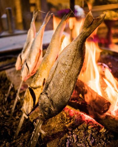 Traditional roast fish grill in Sardinia, showcasing a succulent fish cooked to perfection over an open flame, embodying the authentic flavors of Sardinian cuisine