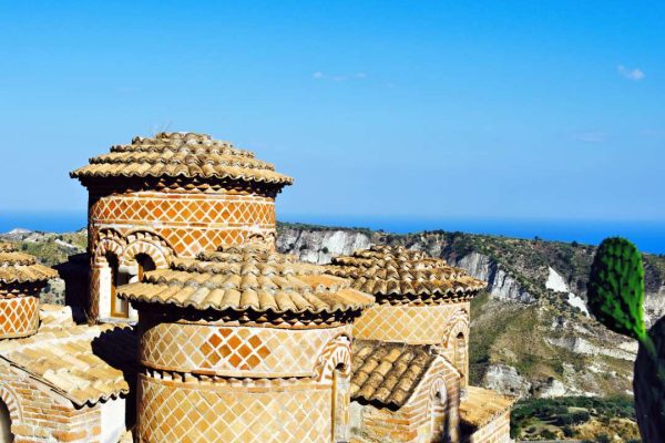 Panoramic view of the domes of the Cattolica church in Stilo, Calabria, Italy, showcasing the historic architecture against the scenic backdrop of the Calabrian landscape.